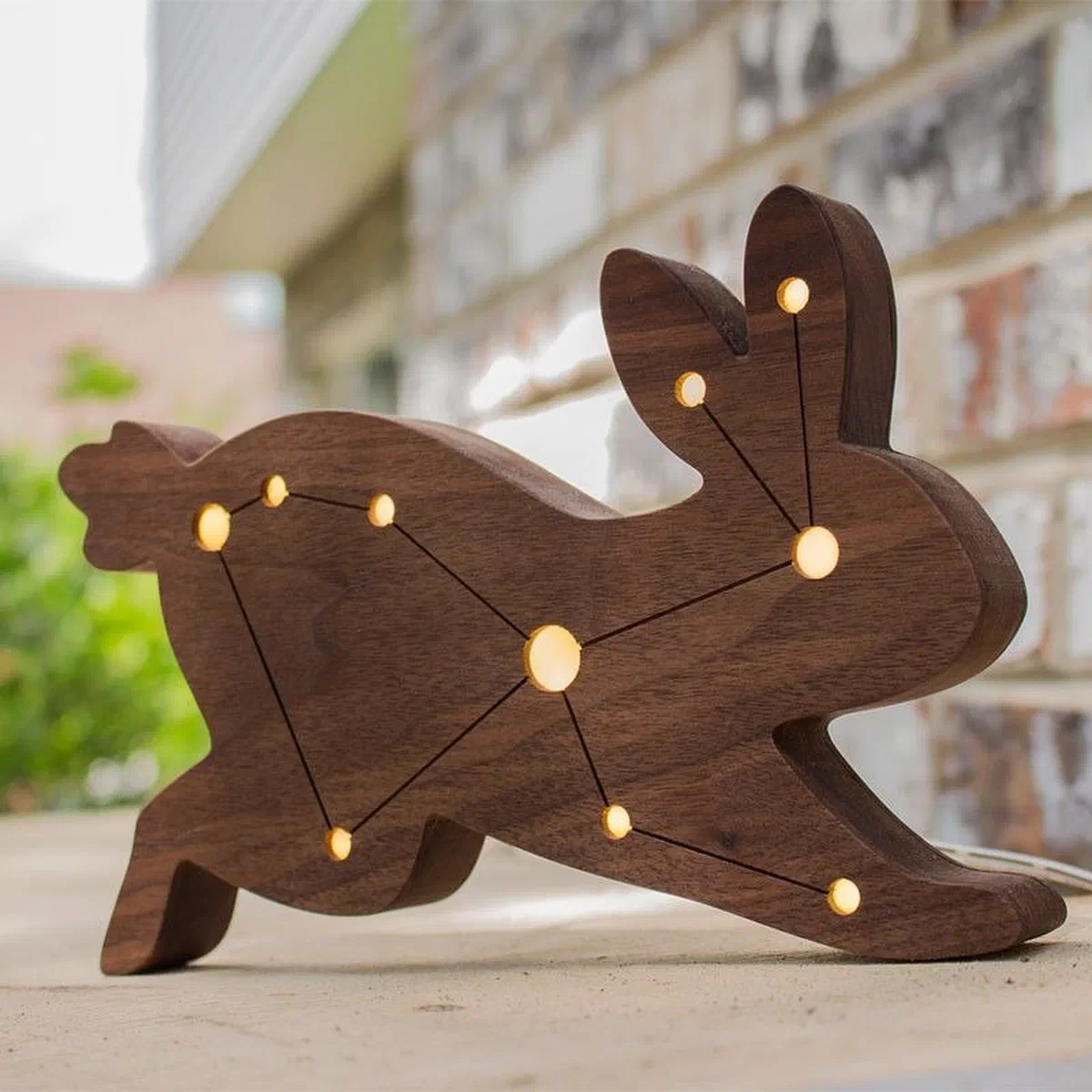 A walnut hare with the Lepus constellation picked out in small lit holes.