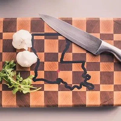 An end grain checkerboard cutting board with a state outline filled in dark epoxy.