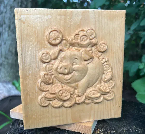 A wooden bank front with a smiling pig and coins carved in relief, photographed outdoors