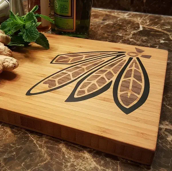 A finished bamboo board with contrasting dark and colored feather inlays