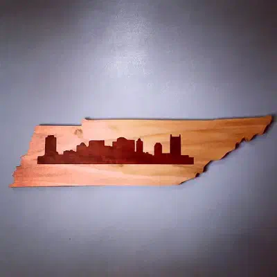Tennessee-shaped board with a dark Nashville skyline inlay set into lighter wood