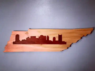 Tennessee-shaped board with a dark Nashville skyline inlay set into lighter wood