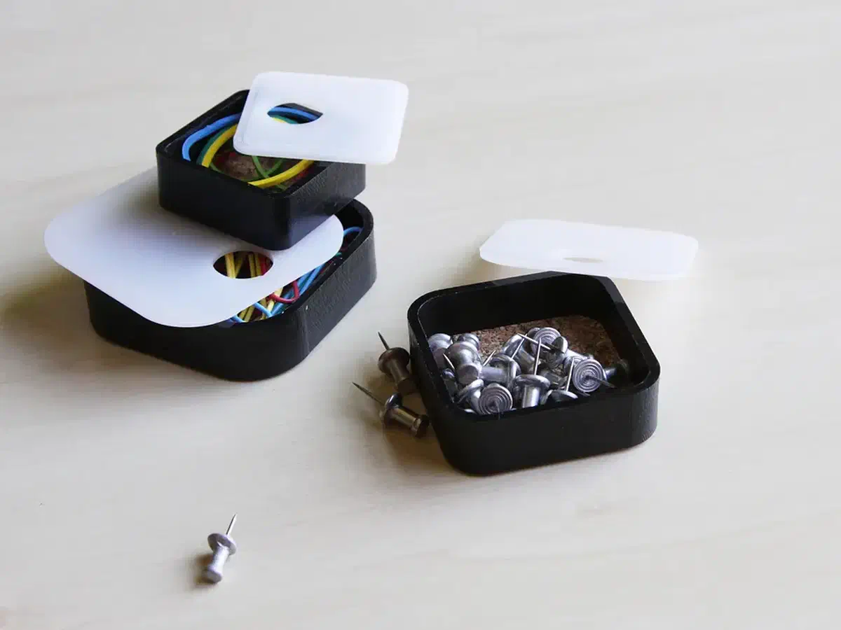 Finished HDPE stacking boxes shown open, including one holding small metal hardware