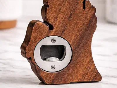 Walnut Michigan-shaped bottle opener with a recessed metal insert visible on its back