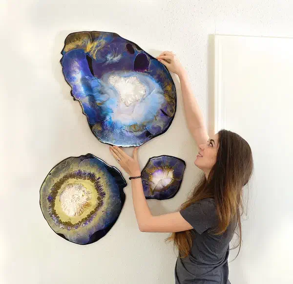 Three finished blue, purple, gold, white, and black resin geode wall pieces mounted together