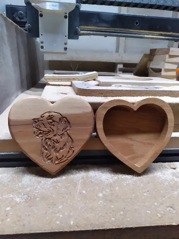 Heart-shaped hickory box beside its removable lid engraved with a dog portrait