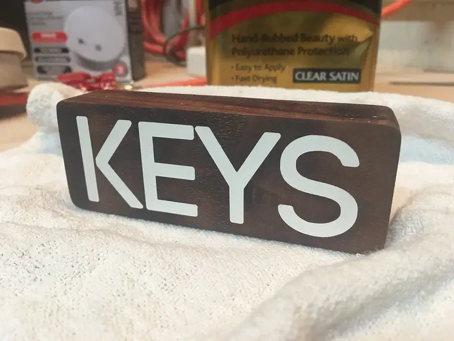 Finished walnut block with crisp white KEYS lettering on a workshop towel