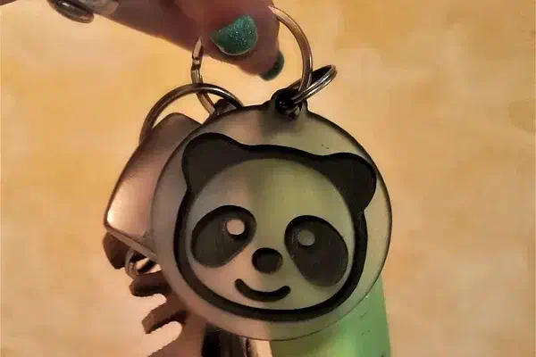 Close crop of the finished panda fob and its split-ring attachment beside keys