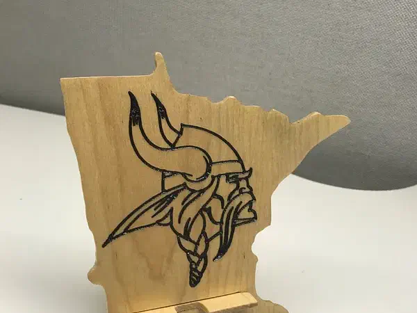 Minnesota-shaped wooden phone stand with a black Viking design and a separate support
