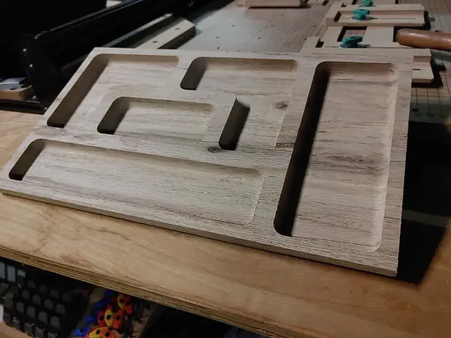 A maple tray with several connected rectangular recessed compartments
