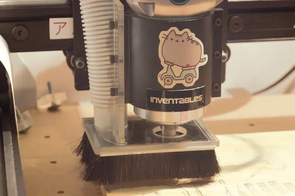 Emily’s transparent acrylic dust shoe and black brush installed around a router