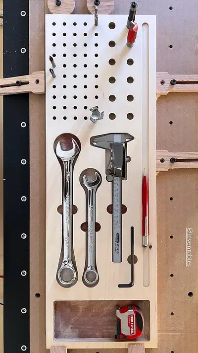 Birch plywood tool board holding wrenches, a caliper and upright router bits
